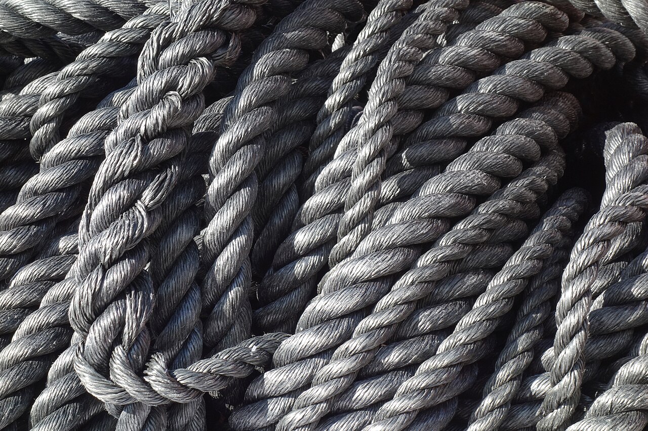 Coils of grey synthetic rope on a dock