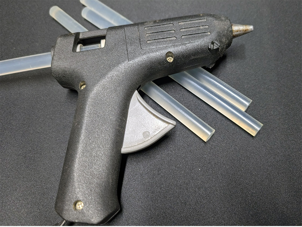 A hot glue gun with a glue stick inserted