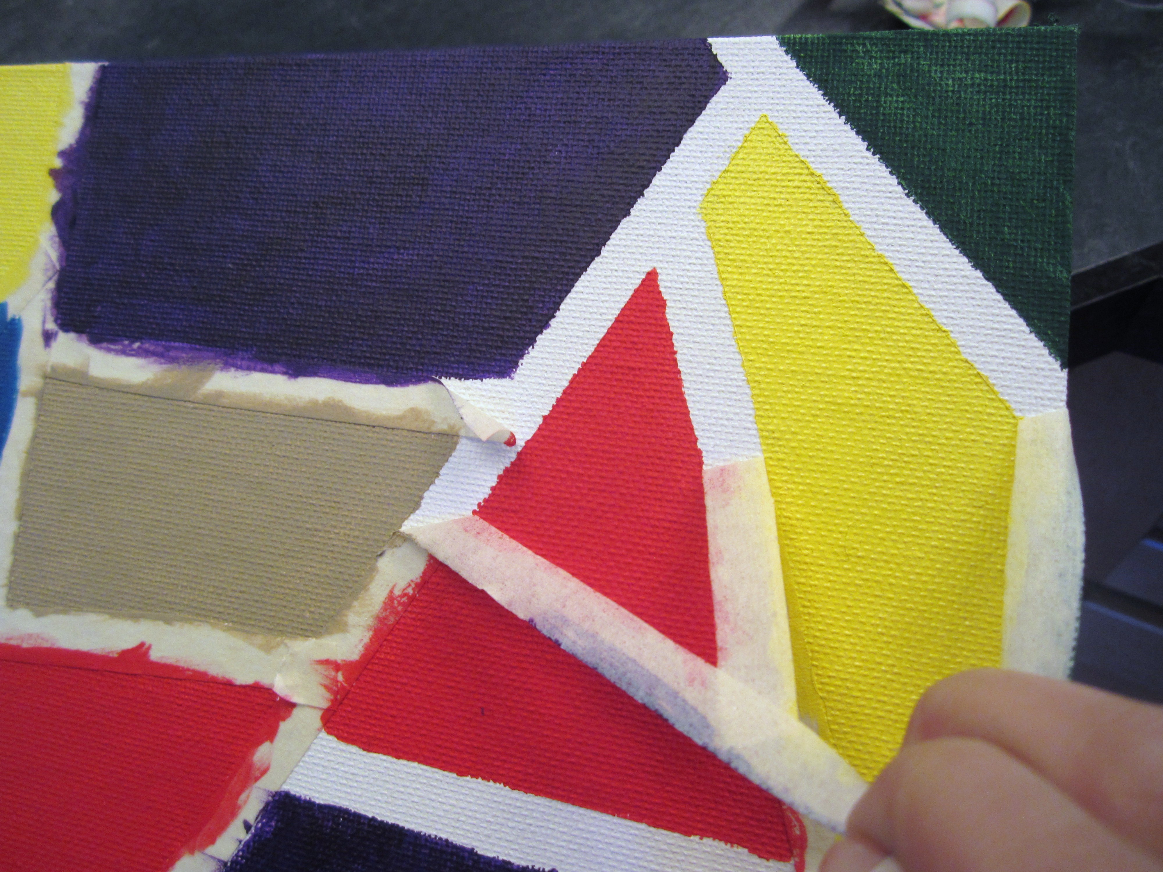 Masking tape being peeled from a painted canvas