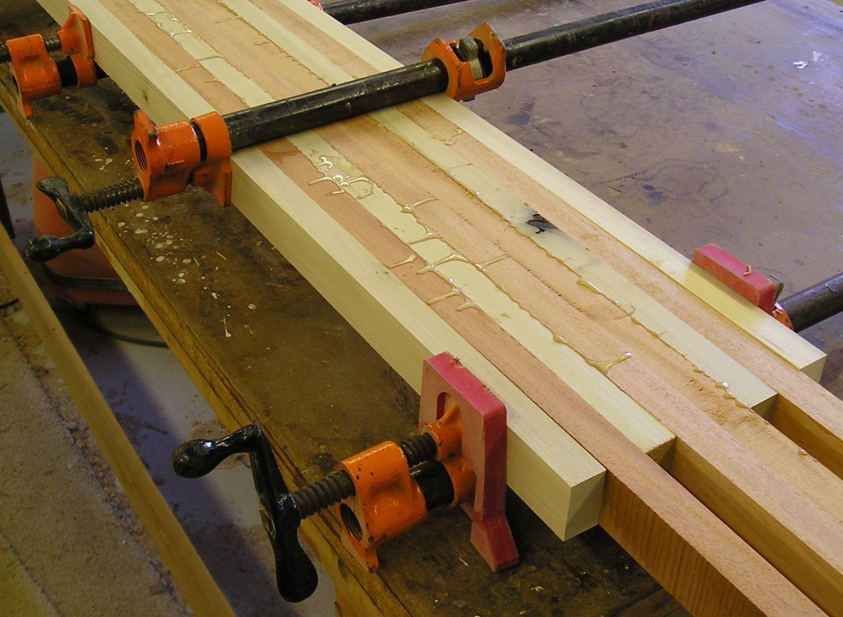 Pipe clamps applying pressure during a wooden glue-up