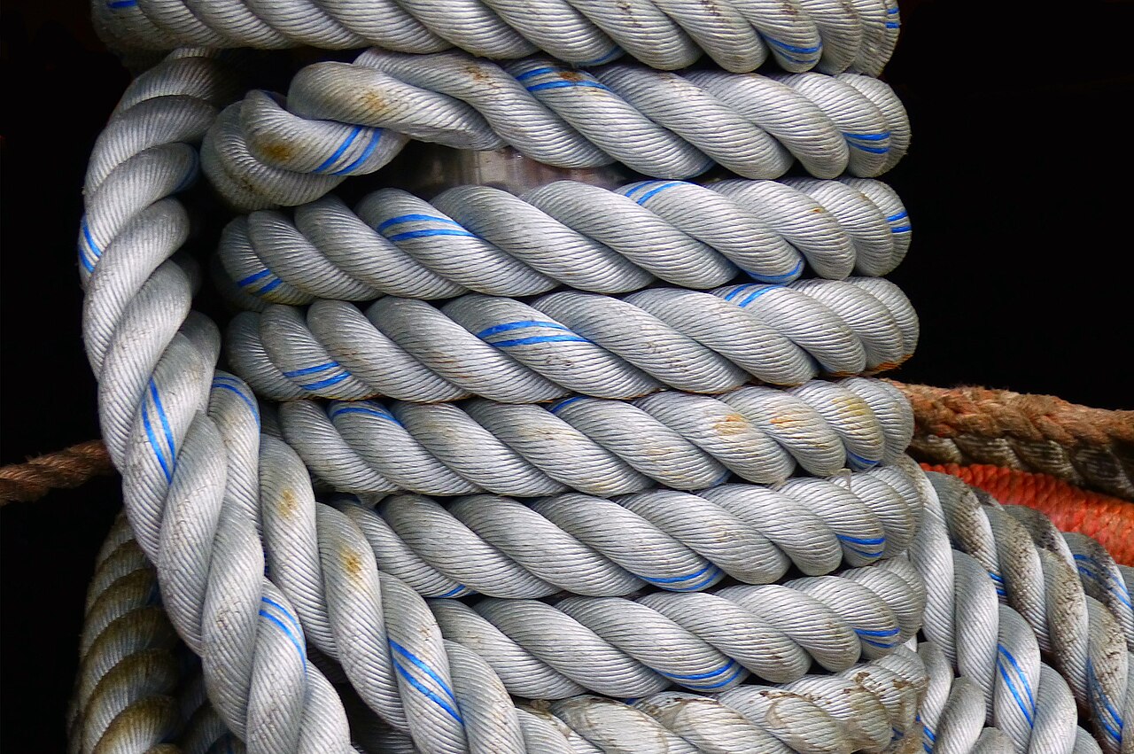 A blue and white mooring rope wrapped around a bollard